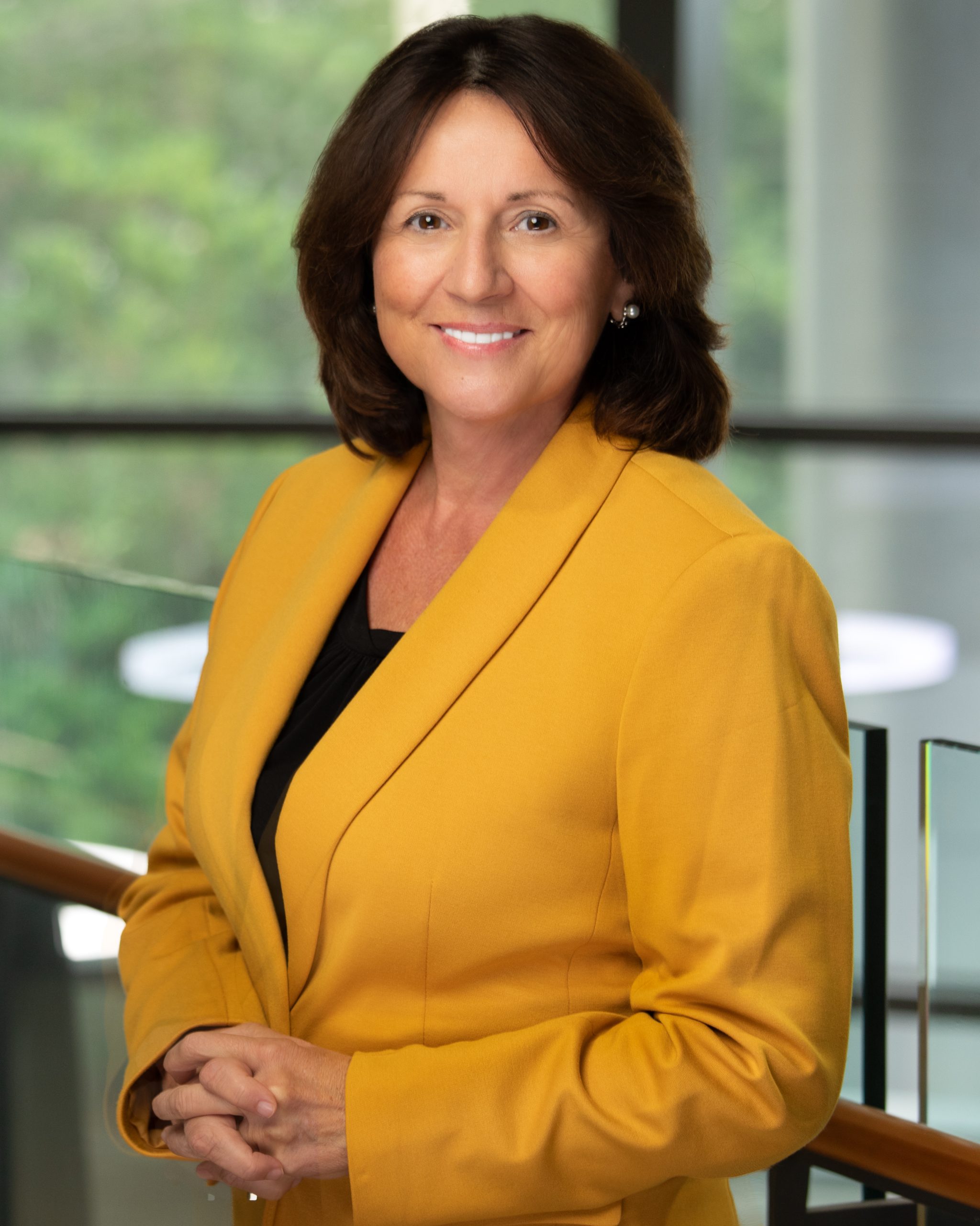 A headshot of Dr. Grace Bochenek. A woman in a yellow blazer smiling into the camera.