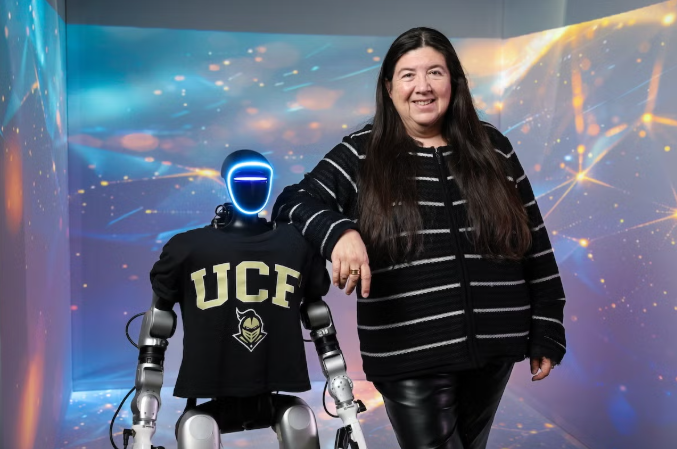 A woman in all black leaning on the shoulder a human robot wearing a UCF t-shirt.